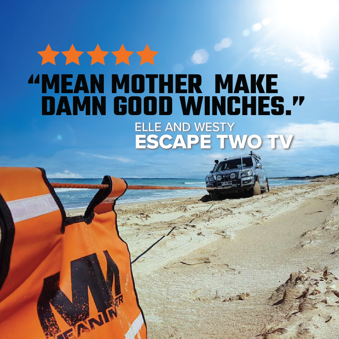 A 4x4 vehicle is stuck on a sandy beach, using the Mean Mother 4x4 Tough Mumma winch with Synthetic Rope 12500LB to pull free. An orange winch bag is in the foreground. Text reads, “Mean Mother make damn good winches.” Five stars are above the quote, attributed to Escape Two TV.