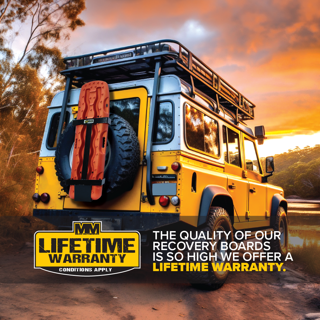 A metallic sunrise red off-road vehicle parked near a body of water at sunset features an Exitrax Recovery Board 1110 Series mounted on the spare tire. The text reads, "The quality of our recovery boards is so high we offer a lifetime warranty." A "Lifetime Warranty" badge is displayed.