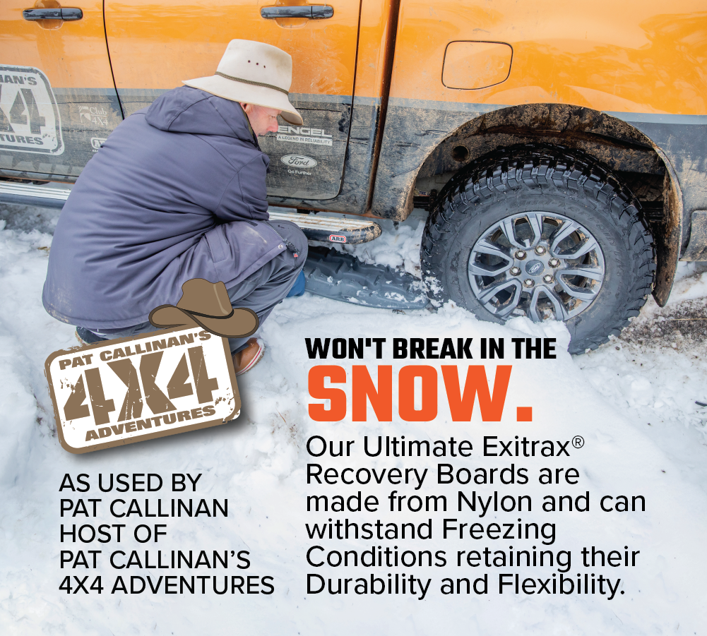 An individual kneels next to an orange vehicle, skillfully positioning an Exitrax Recovery Board Ultimate 1150 - Aqua Marine under a tire on snow-covered ground. The description highlights the board's robust and flexible performance in icy conditions, with endorsement from Pat Callinan's 4x4 Adventures.