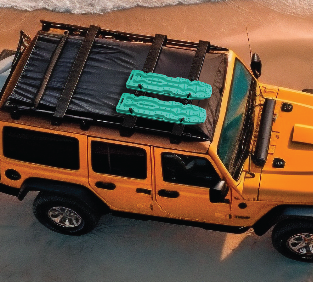 An Aqua Marine Exitrax off-road vehicle was parked on a sandy beach near the ocean, displaying its Exitrax Recovery Board Ultimate 1150 - Aqua Marine, Pair secured with precision on top, courtesy of the reliable Recovery Board Mounts Bundle. Waves gently crashed onto the shore nearby, completing the rugged and serene scene.