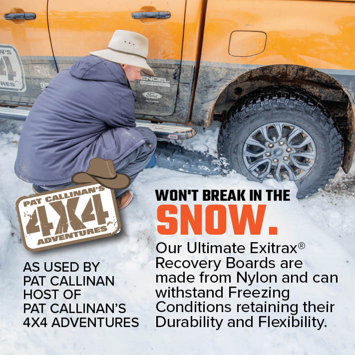 A person in a winter jacket and beanie kneels beside an orange vehicle, attaching an Exitrax Recovery Board Ultimate 1150 - Blood Orange from the pair they have, to a snow-covered tire using the provided recovery board mounts. Text on the image highlights the board's durability in freezing conditions and mentions it is used by Pat Callinan, host of "4X4 Adventures".