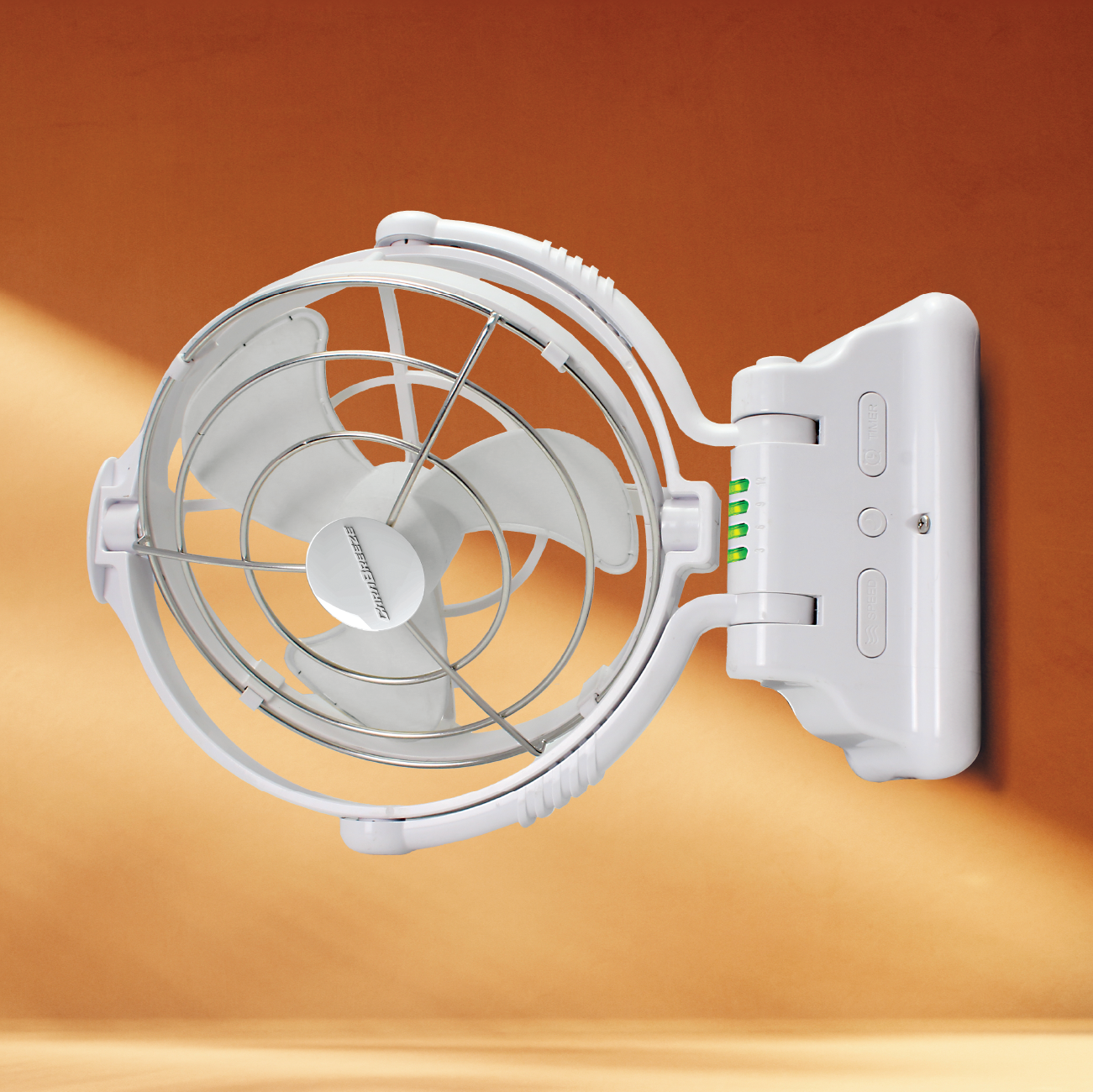 The Carabreeze Caravan Fan by Explore is displayed against an orange background. This white wall-mounted fan comes with a grill cover and three blades, boasting a brushless motor for quieter operation. It also includes a battery power indicator featuring four green lights, and offers the convenience of wireless remote control.