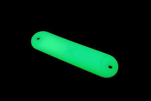 The Mean Mother 4x4 Glo X Straight Marker is a glowing green, cylindrical tool with rounded ends and holes at each end, displayed against a black background.