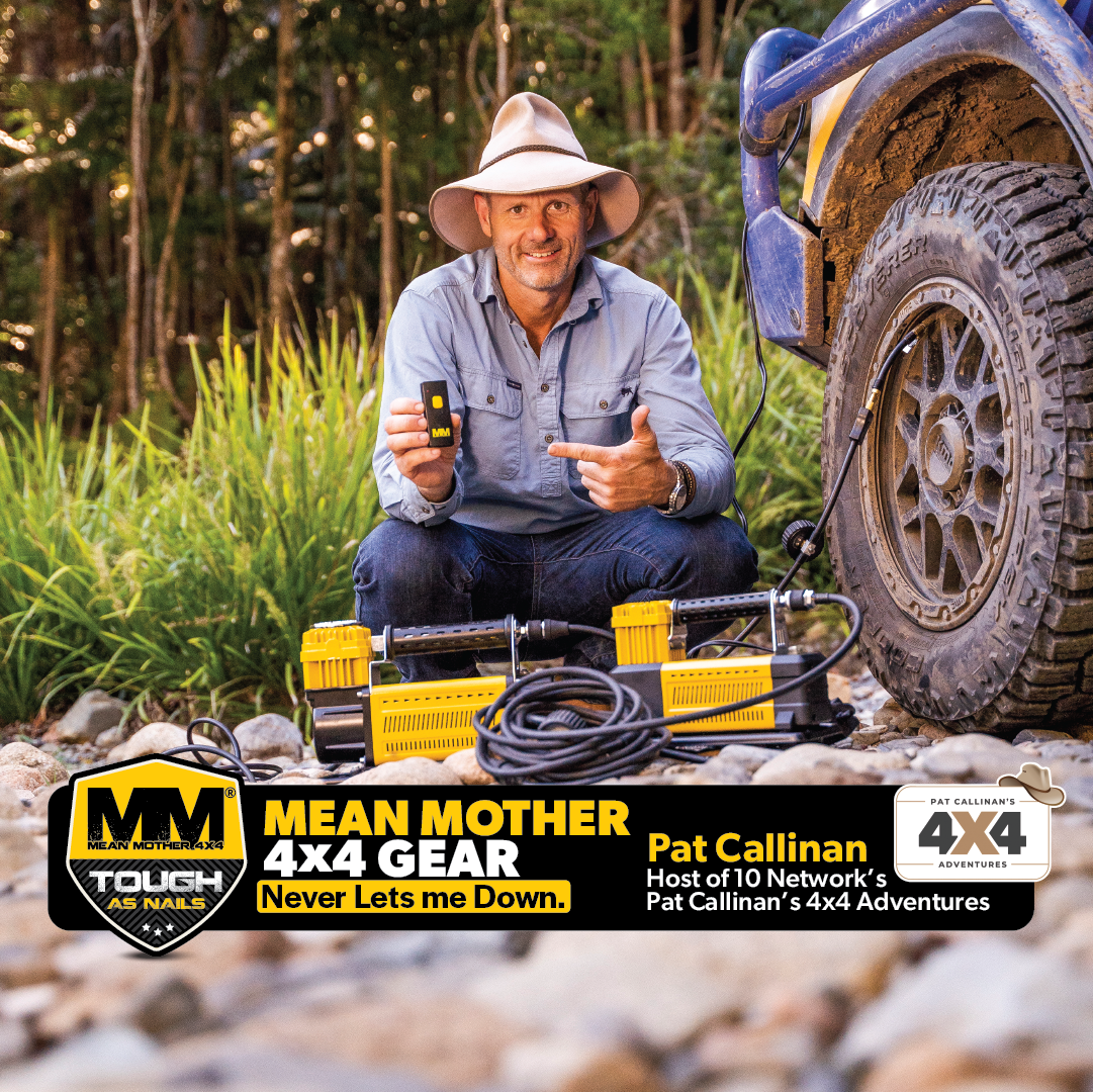 A man wearing a hat kneels outside beside a blue 4x4 vehicle, holding the Mean Mother Air Compressor with Wireless Remote Control 180lpm, distinguished by its powerful yellow design. The text reveals him as Pat Callinan, host of a 4x4 adventure show, making the most of this impressive gear that comes with a five-year warranty.