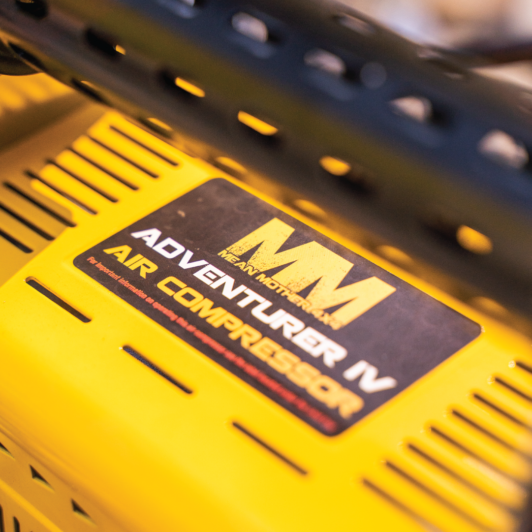 Close-up of a yellow Mean Mother Air Compressor with Wireless Remote Control, delivering an impressive 180L/Min free air flow. The label is black with yellow and white text, highlighting the brand and product name, and comes with a reassuring 5-year warranty.