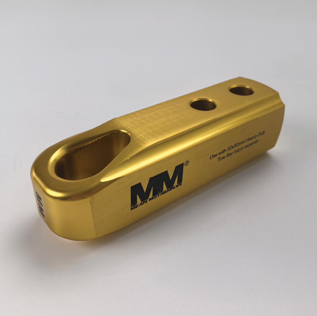 A gold billet aluminium Recovery Hitch by Mean Mother 4x4 with three holes, an oval cutout, and logo; suitable for SDS/Schramm Heavy Duty tow bar heads or use as a 4WD recovery hitch.